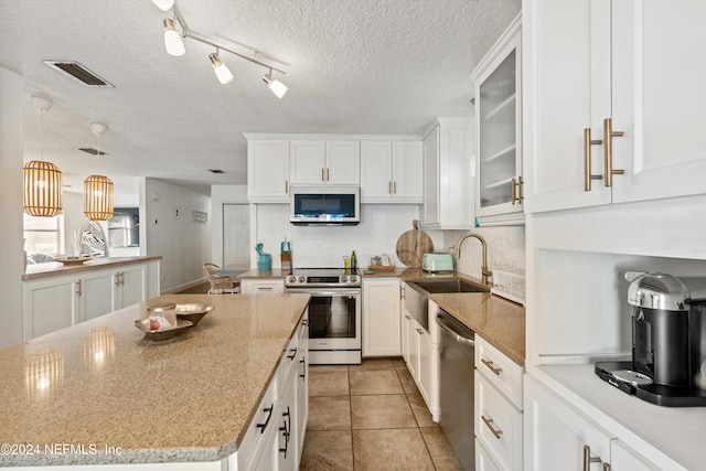 kitchen featuring white cabinetry, appliances with stainless steel finishes, a textured ceiling, and sink