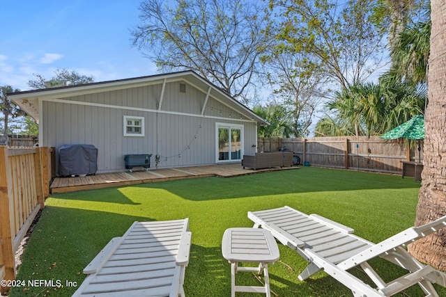 back of house featuring a lawn and a deck