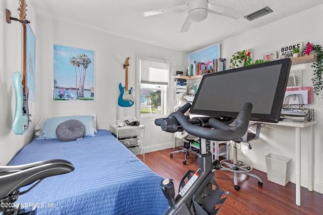 bedroom featuring ceiling fan, a textured ceiling, and dark hardwood / wood-style flooring