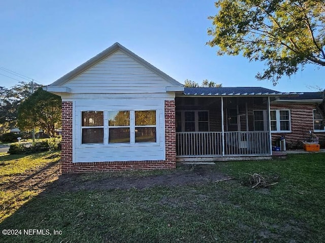 rear view of property featuring a lawn