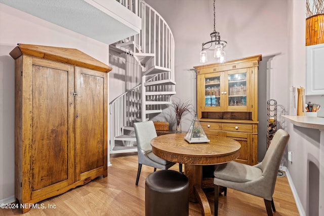 dining room with light hardwood / wood-style floors and a notable chandelier