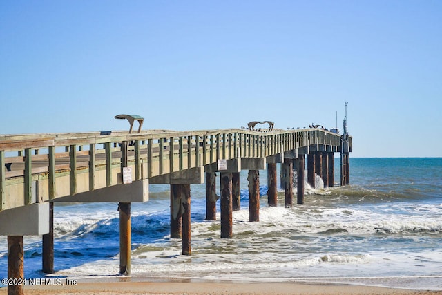 view of dock with a water view and a view of the beach