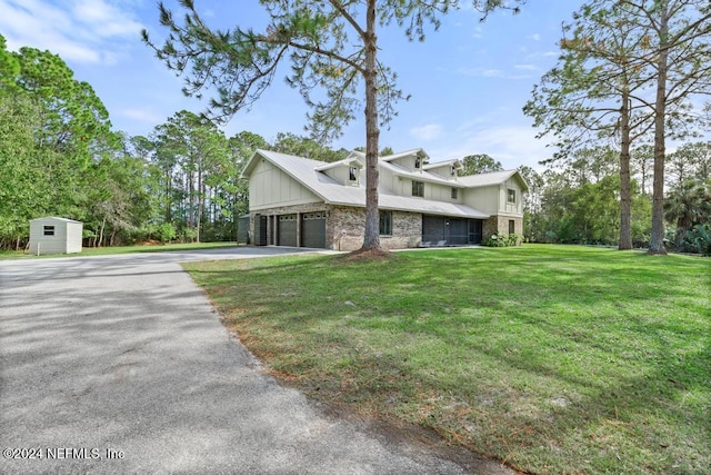 view of front facade featuring a front lawn, a storage unit, and a garage