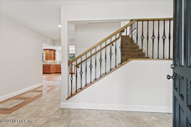 staircase featuring tile patterned flooring