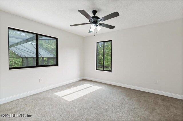 unfurnished room with a textured ceiling, carpet floors, and ceiling fan