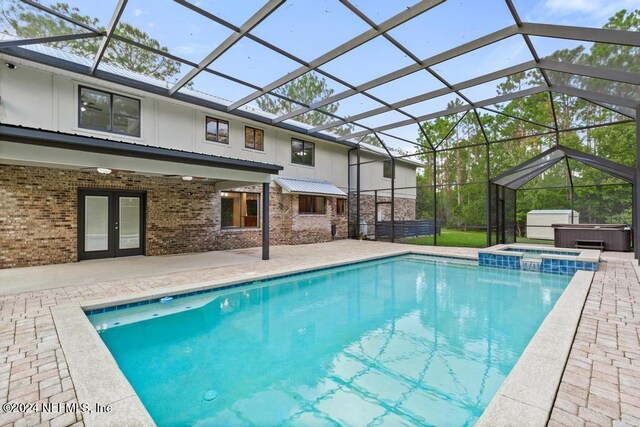 view of swimming pool with an outdoor hot tub, a patio, a lanai, and french doors