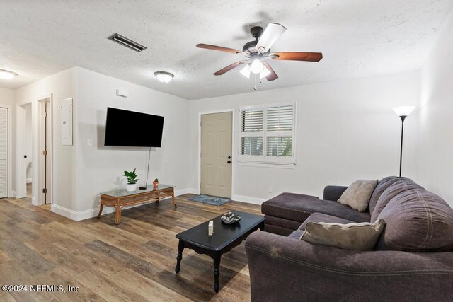 living room featuring a textured ceiling, hardwood / wood-style flooring, and ceiling fan