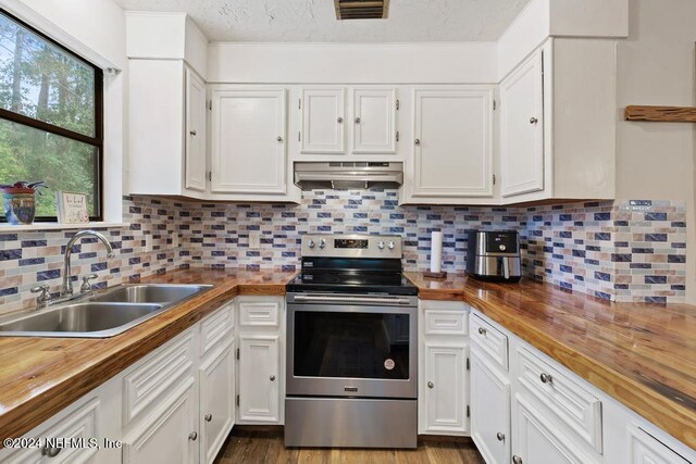 kitchen featuring extractor fan, sink, stainless steel electric range oven, white cabinets, and wood counters