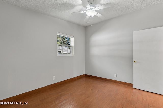 spare room with ceiling fan, wood-type flooring, and a textured ceiling