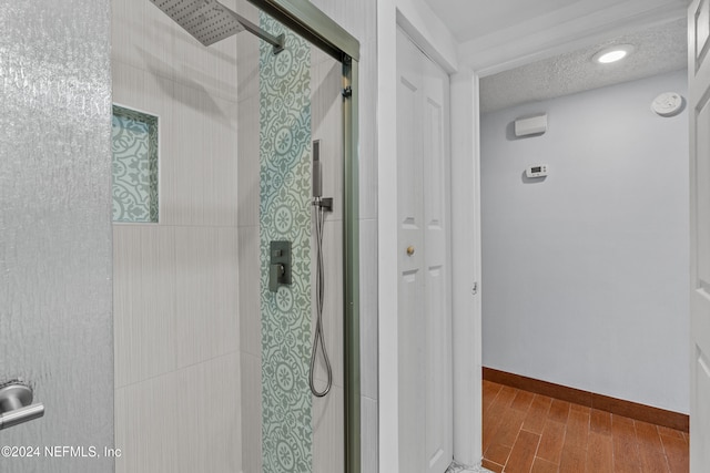 bathroom featuring hardwood / wood-style floors, a textured ceiling, and an enclosed shower