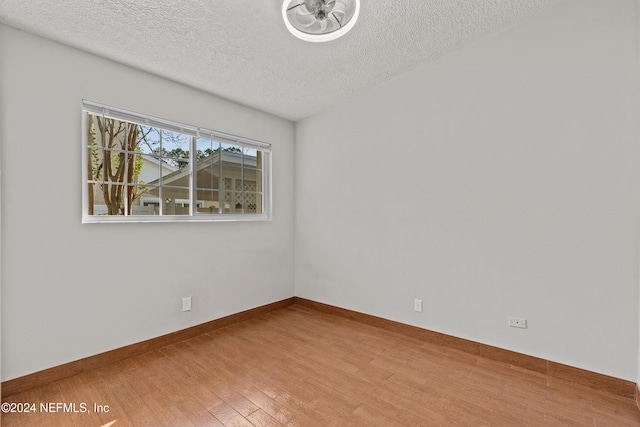 empty room with a textured ceiling and hardwood / wood-style flooring