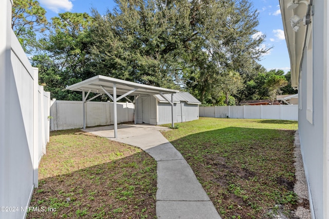 view of yard featuring a carport and a storage shed