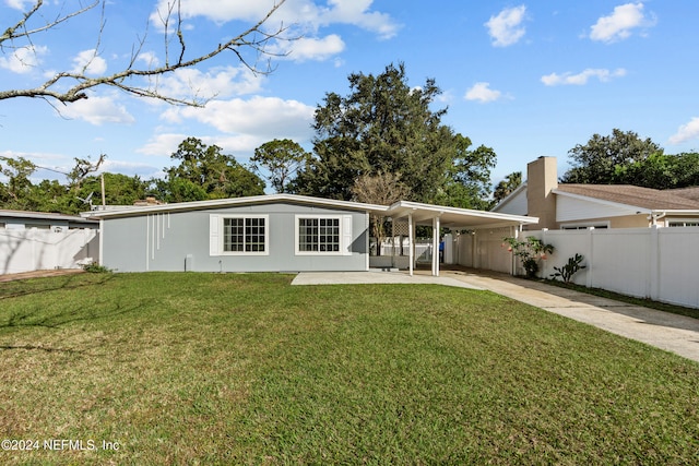 rear view of house with a yard and a carport