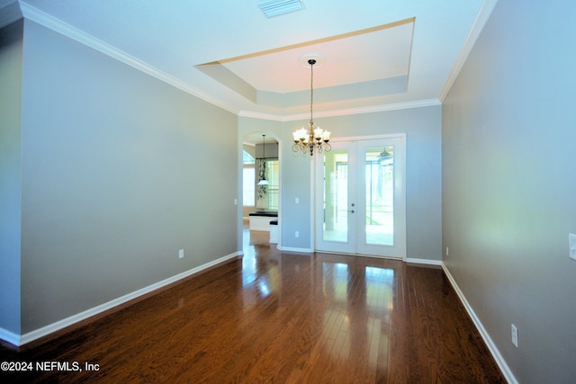 unfurnished room with a raised ceiling, crown molding, french doors, and dark wood-type flooring