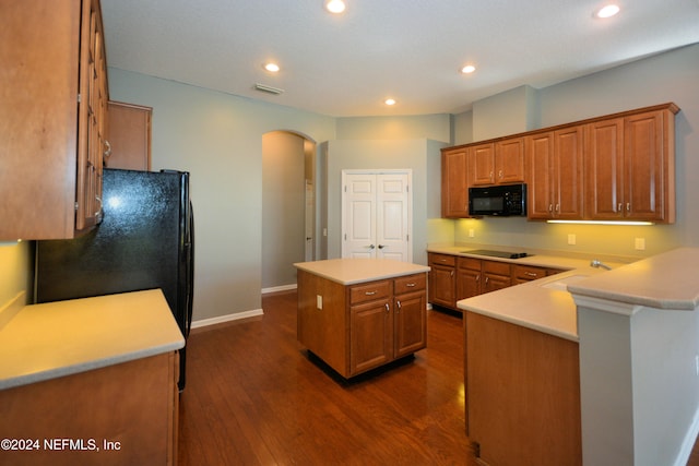 kitchen featuring sink, a center island, dark wood-type flooring, and black appliances