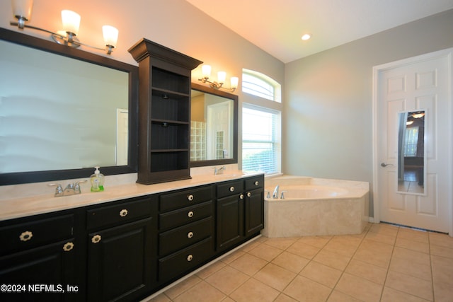 bathroom with tile patterned floors, a washtub, and vanity