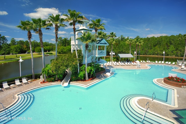 view of swimming pool with a water view, a patio area, and a water slide