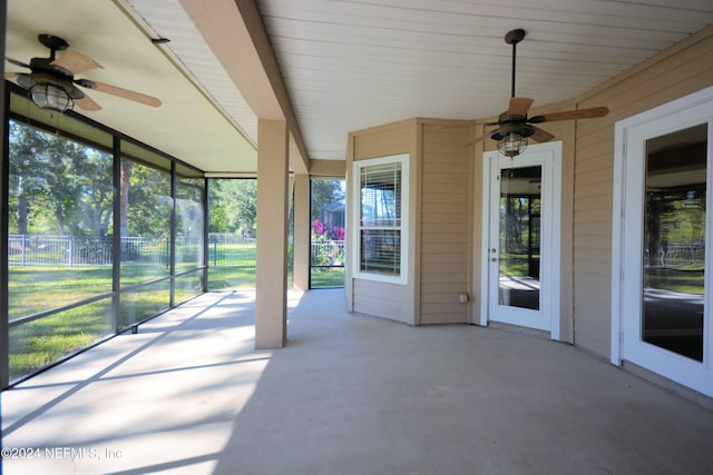 unfurnished sunroom with ceiling fan