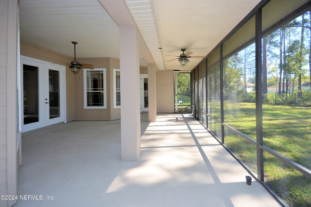 unfurnished sunroom featuring ceiling fan and french doors