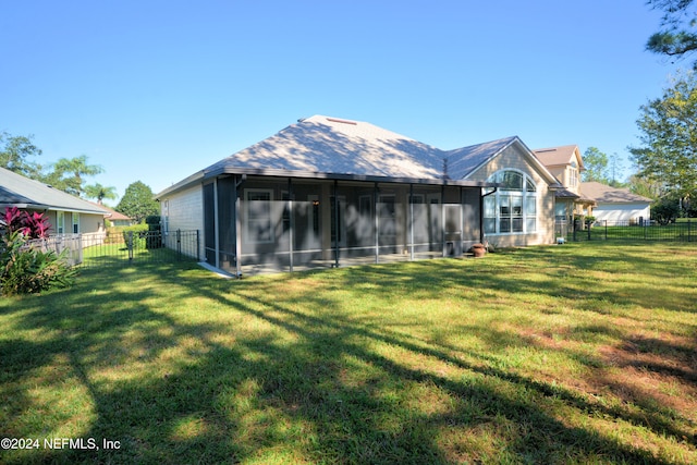 rear view of house with a lawn and a sunroom