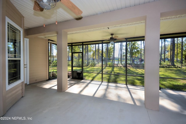 unfurnished sunroom with ceiling fan and plenty of natural light