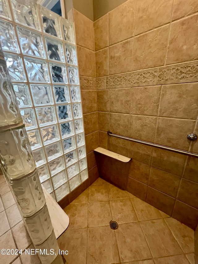 bathroom featuring tiled shower and tile patterned flooring