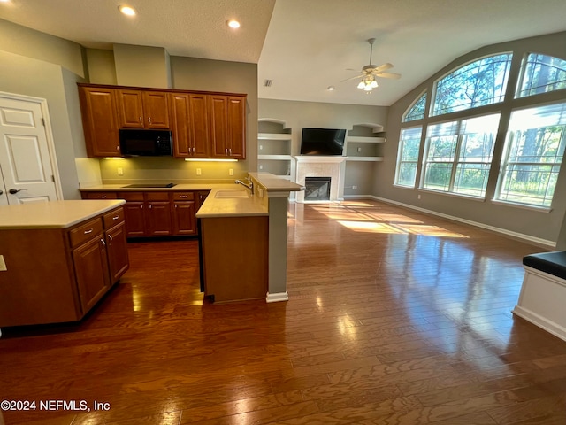 kitchen featuring black appliances, sink, dark hardwood / wood-style floors, ceiling fan, and built in shelves