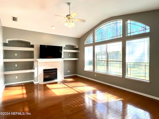 unfurnished living room with ceiling fan, built in features, a fireplace, hardwood / wood-style floors, and lofted ceiling