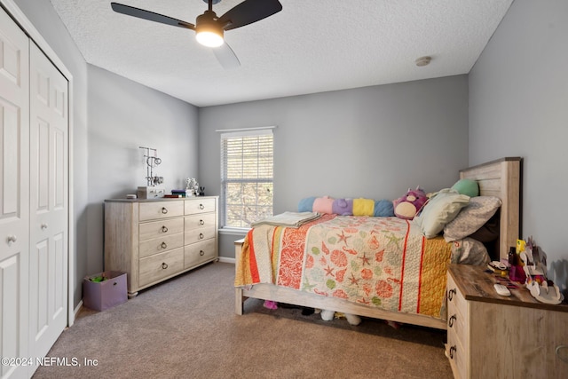 bedroom featuring a textured ceiling, carpet floors, ceiling fan, and a closet