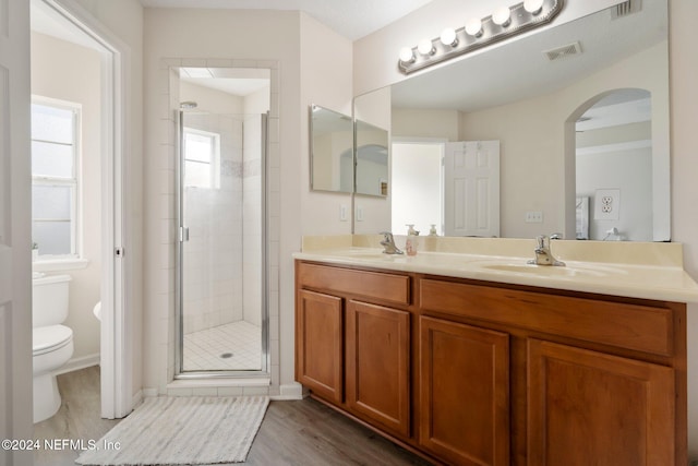 bathroom featuring toilet, vanity, wood-type flooring, and walk in shower