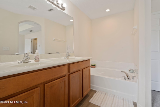 bathroom featuring a bath, hardwood / wood-style flooring, and vanity