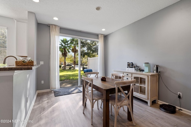 dining room with a textured ceiling and light hardwood / wood-style flooring