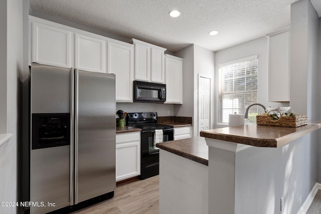 kitchen with white cabinets, kitchen peninsula, black appliances, a textured ceiling, and light wood-type flooring