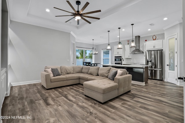 living room featuring crown molding, sink, dark hardwood / wood-style floors, and ceiling fan with notable chandelier