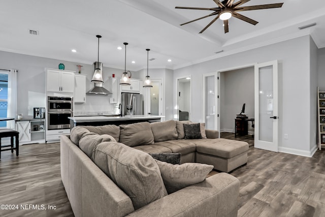 living room featuring hardwood / wood-style floors, ceiling fan, sink, and crown molding