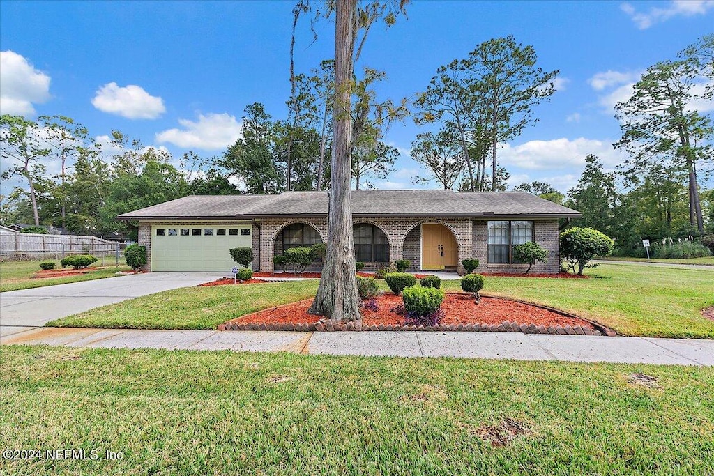 ranch-style home featuring a garage and a front yard