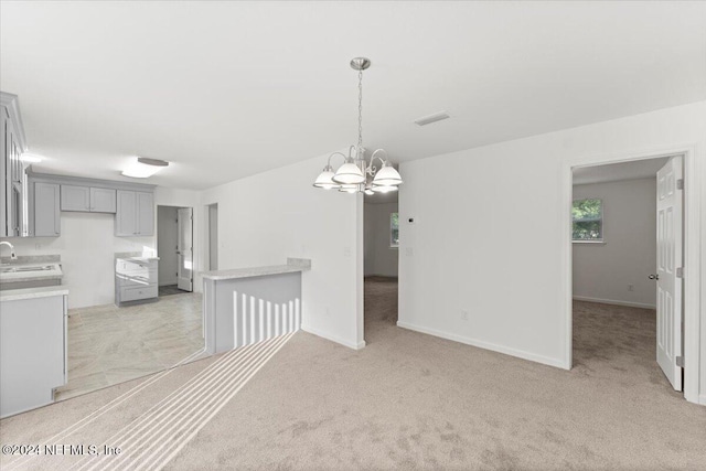 interior space featuring light colored carpet, a notable chandelier, and sink