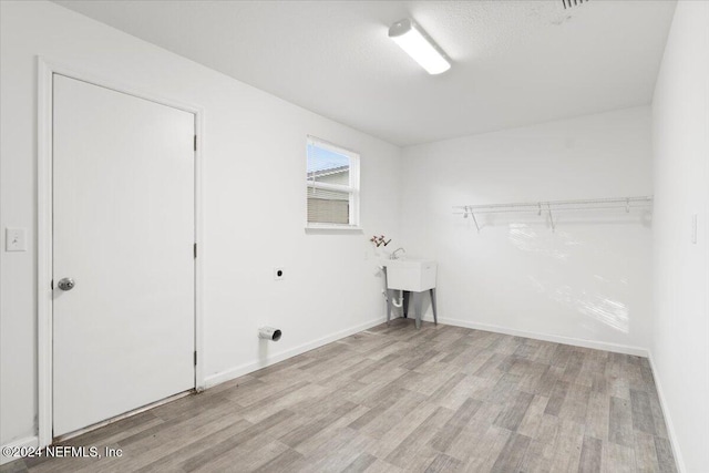 washroom featuring light wood-type flooring and electric dryer hookup