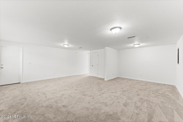 basement with light carpet and a textured ceiling