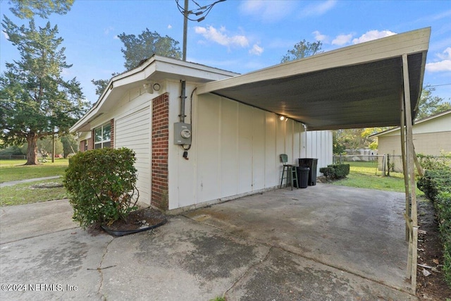 view of property exterior with a carport and a lawn