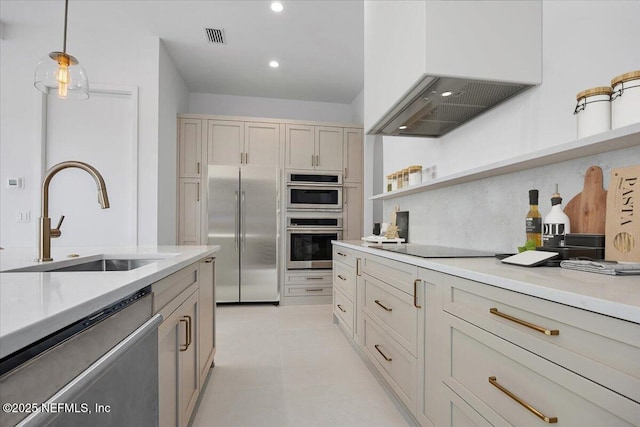 kitchen featuring backsplash, sink, hanging light fixtures, stainless steel appliances, and custom range hood