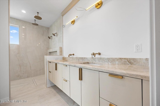 bathroom featuring a tile shower and vanity