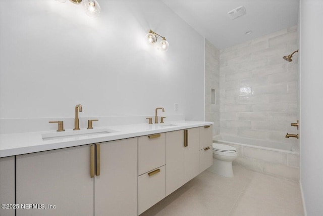 full bathroom featuring toilet, vanity, tiled shower / bath, and tile patterned flooring