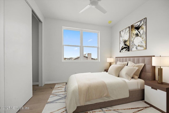 bedroom featuring ceiling fan, a closet, and light hardwood / wood-style floors