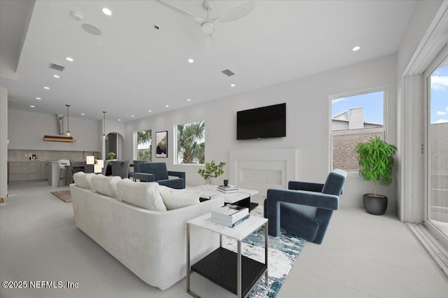 living room with ceiling fan and a fireplace