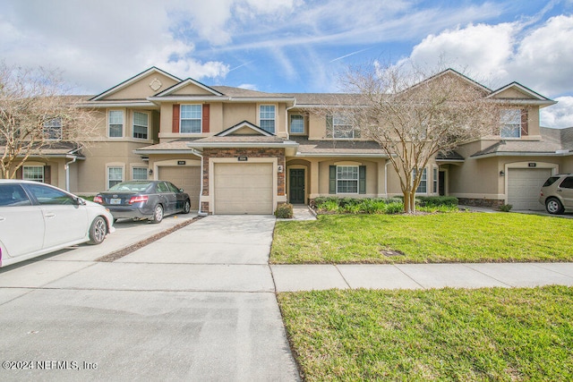 view of property with a garage and a front yard