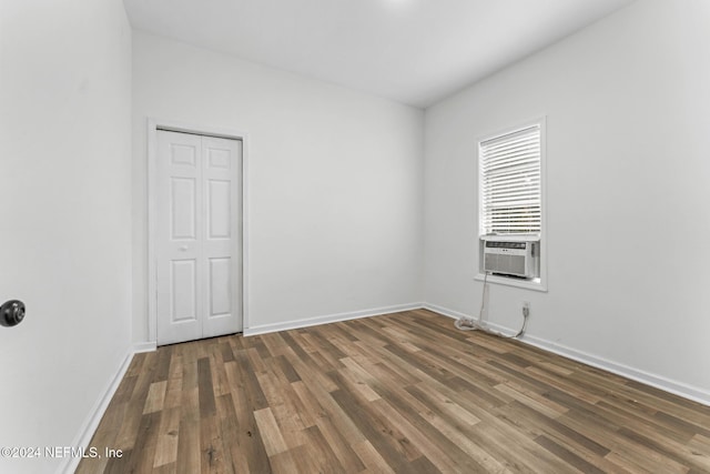 empty room with dark hardwood / wood-style flooring and cooling unit