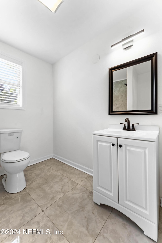 bathroom featuring toilet, vanity, and tile patterned flooring