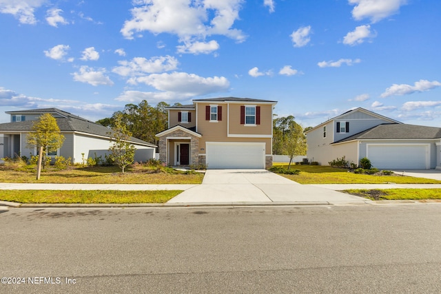 view of front of property featuring stone siding, an attached garage, a front lawn, and concrete driveway