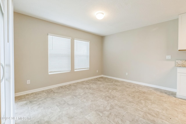 unfurnished room with a textured ceiling